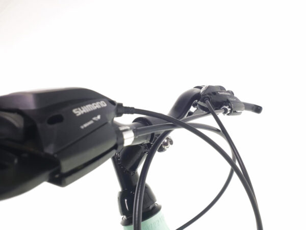 Cykelstyre med Shimano-växlar mot vit bakgrund.