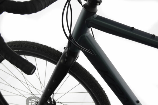 Närbild av cykelram och styrhuvud, svart och grön färg.