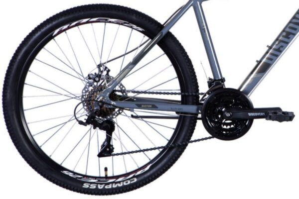 Del av cykel med hjul och kedja synlig.